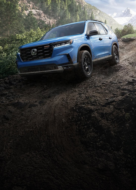 2025 Honda Pilot TrailSport in Diffused Sky Blue Pearl driving off-road.
