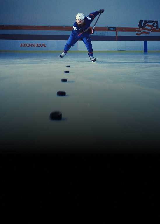 Kendall Coyne Schofield, U.S. Olympian ice hockey, in mid-shot action on an indoor ice rink.