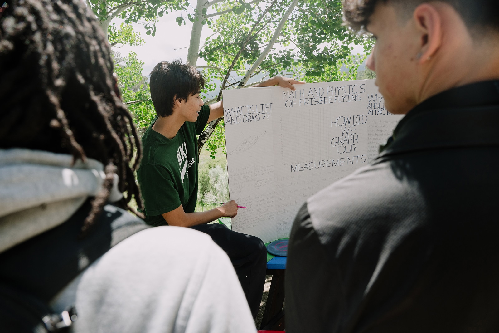 A student outdoors giving a talk on the physics of a Frisbee.