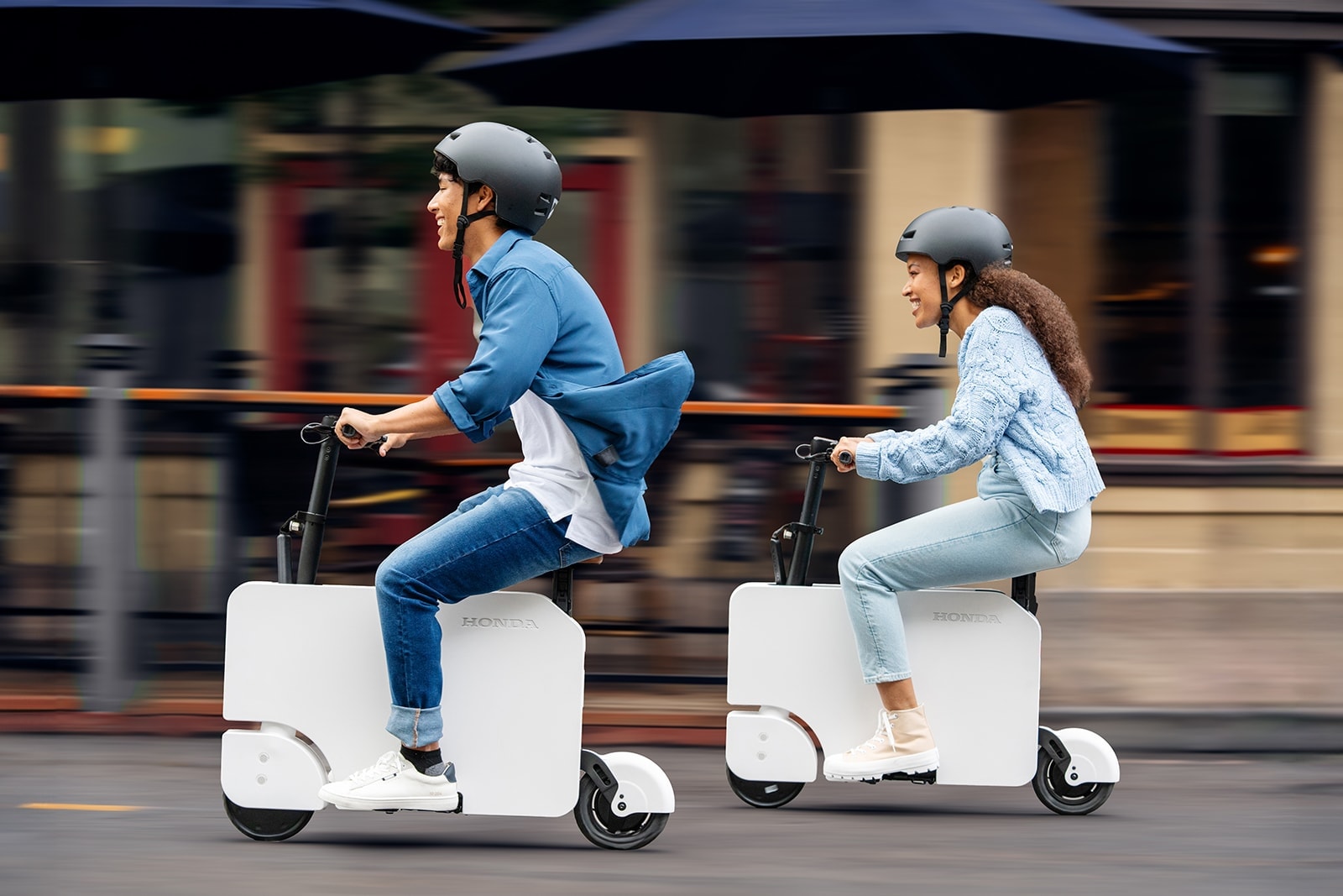 Two guys having fun and driving an All-Electric Honda Motocompacto.
